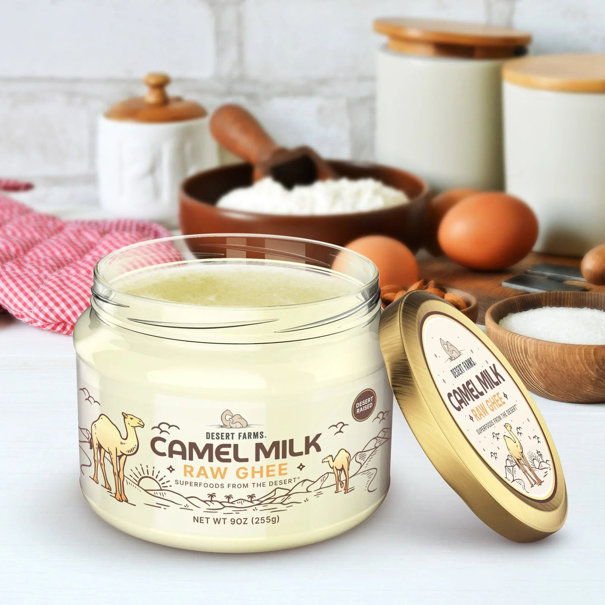Jar of camel milk raw ghee with a gold lid on a kitchen counter.