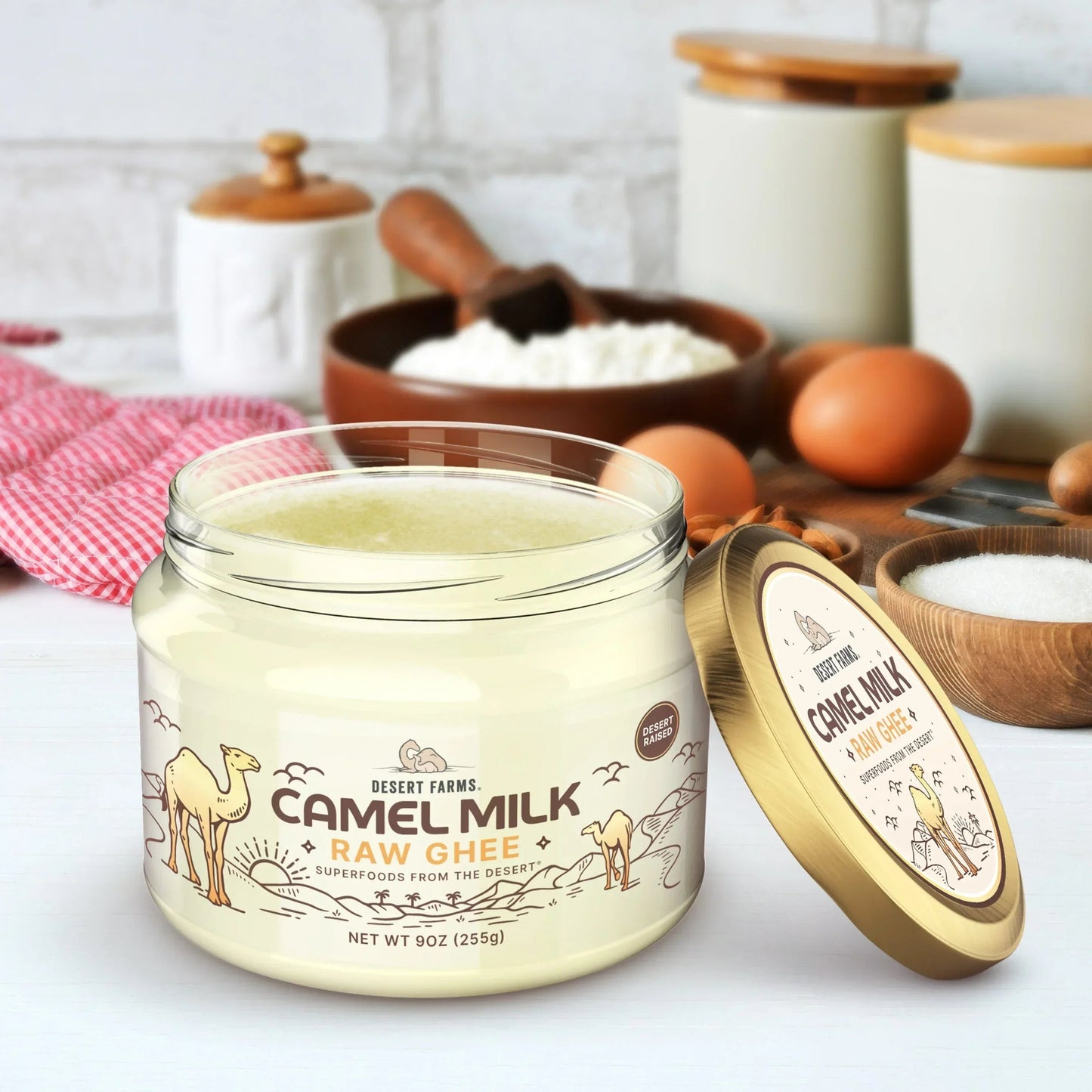 Jar of camel milk raw ghee with a gold lid on a kitchen counter.